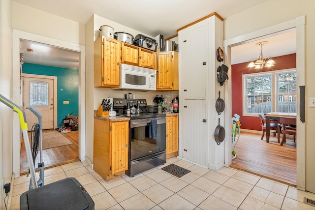 kitchen with hanging light fixtures, black / electric stove, a notable chandelier, and light hardwood / wood-style flooring