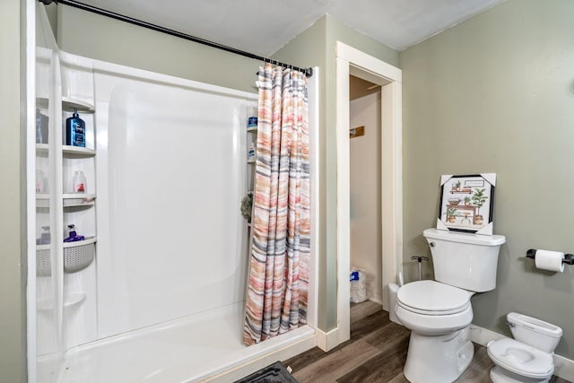 bathroom with hardwood / wood-style floors, curtained shower, and toilet