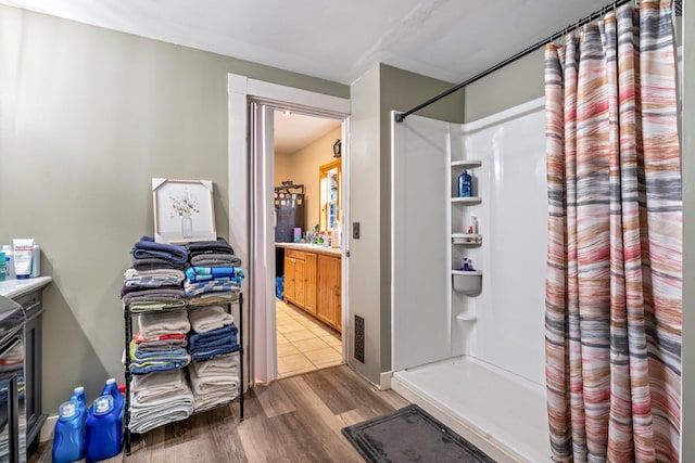 bathroom featuring a shower and wood-type flooring