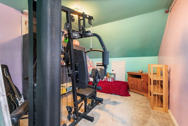 workout area featuring light colored carpet and vaulted ceiling