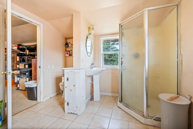 bathroom featuring walk in shower, toilet, vaulted ceiling, and tile patterned flooring