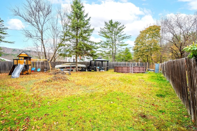 view of yard featuring a fenced in pool and a playground