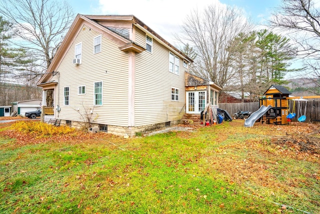 back of house with a playground and a lawn