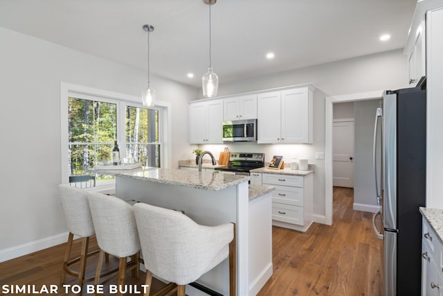 kitchen with dark hardwood / wood-style flooring, white cabinetry, stainless steel appliances, and an island with sink