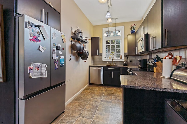 kitchen with stainless steel appliances, backsplash, pendant lighting, sink, and rail lighting