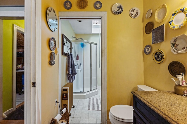 bathroom with walk in shower, vanity, toilet, and tile patterned floors