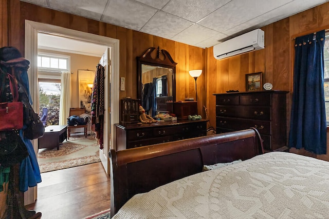 bedroom with wood walls and a wall mounted air conditioner