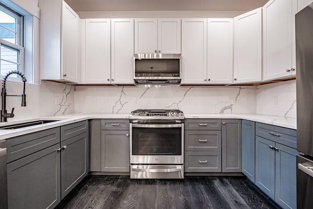 kitchen with gray cabinetry, sink, stainless steel appliances, white cabinets, and dark hardwood / wood-style floors