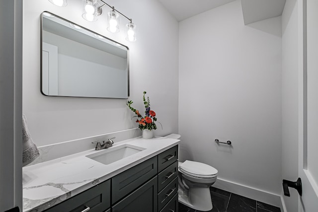 bathroom with toilet, vanity, and tile patterned floors