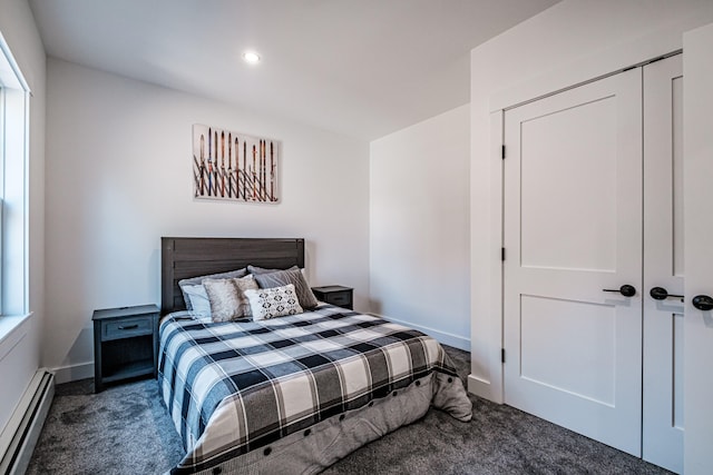 carpeted bedroom with a baseboard radiator and a closet