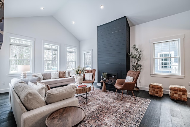 living room featuring dark wood-type flooring, a large fireplace, and high vaulted ceiling