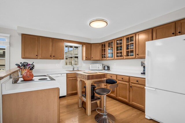 9 Robert Ln, Wells, ME 04090 - kitchen with white appliances, a sink, glass insert cabinets, light countertops, and light wood-style floors