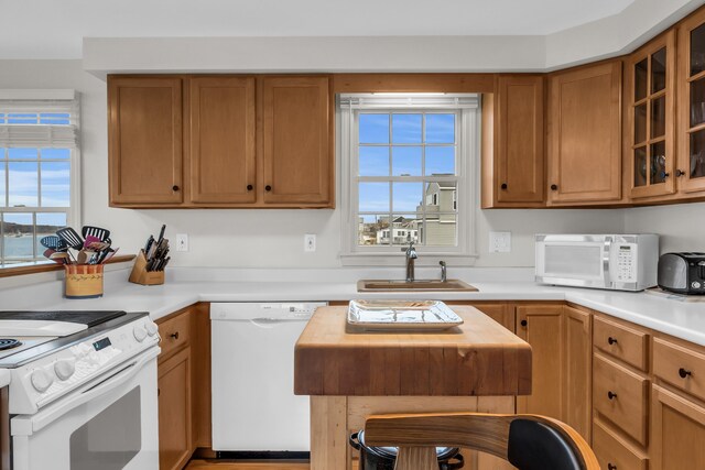 9 Robert Ln, Wells, ME 04090 - kitchen with white appliances, a sink, light countertops, glass insert cabinets, and brown cabinetry