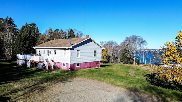 view of property exterior with a deck and a lawn