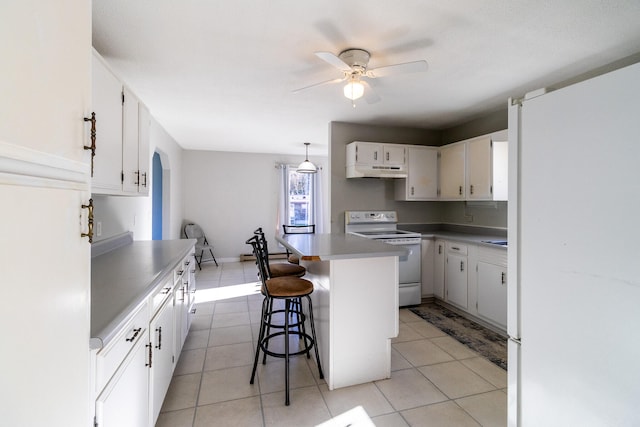 kitchen with a breakfast bar area, white cabinetry, a center island, and white appliances