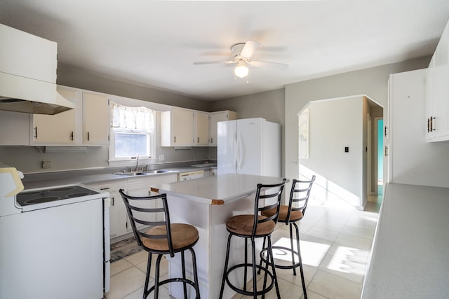 kitchen with white cabinets, ceiling fan, sink, and white appliances