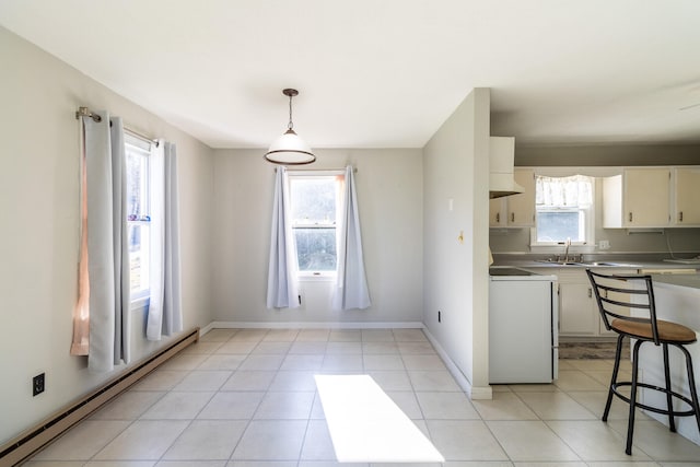 kitchen with a wealth of natural light, a baseboard radiator, white stove, and stainless steel counters