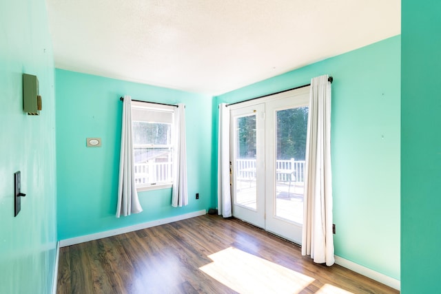 doorway to outside featuring a wealth of natural light, a textured ceiling, and hardwood / wood-style flooring