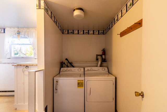 clothes washing area featuring a baseboard heating unit and washing machine and dryer