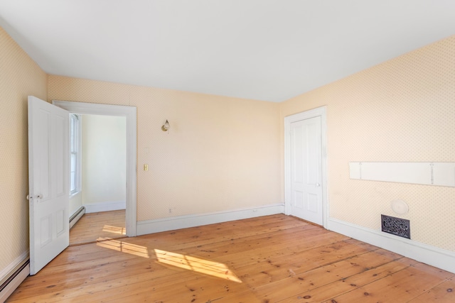 spare room with light hardwood / wood-style flooring and a baseboard heating unit