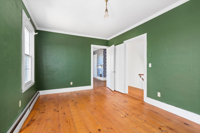 unfurnished bedroom with baseboard heating, crown molding, and light hardwood / wood-style floors