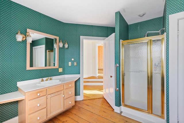 bathroom with vanity, a shower with shower door, and hardwood / wood-style floors