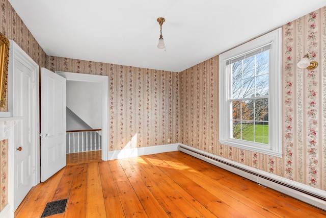 interior space featuring a baseboard heating unit and hardwood / wood-style flooring