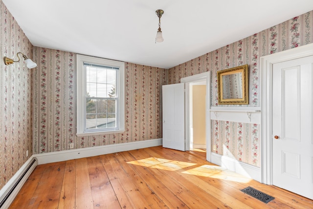 unfurnished bedroom featuring a baseboard radiator and hardwood / wood-style floors