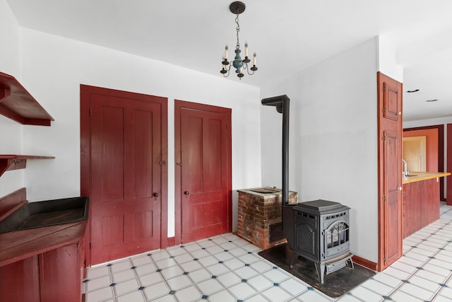 entryway with a wood stove and a chandelier