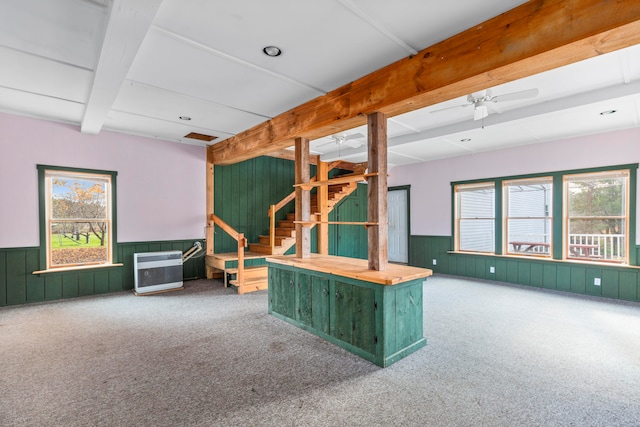 interior space with carpet flooring, beamed ceiling, plenty of natural light, and ceiling fan