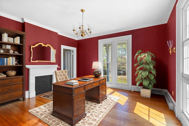 office with light hardwood / wood-style floors, ornamental molding, and a chandelier