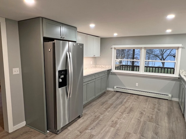 kitchen featuring light hardwood / wood-style flooring, a baseboard heating unit, gray cabinets, and stainless steel fridge