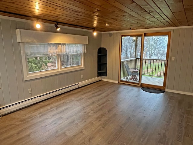 spare room with wood walls, wooden ceiling, wood-type flooring, and baseboard heating