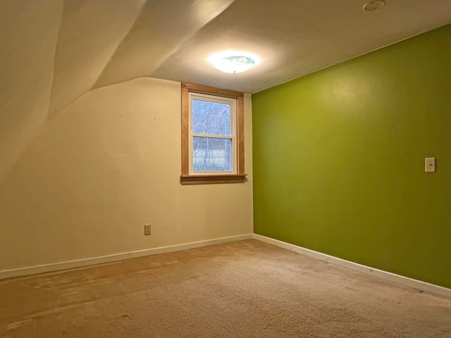 additional living space featuring lofted ceiling and carpet flooring