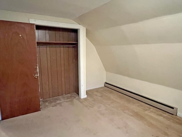 additional living space featuring light carpet, a baseboard radiator, and vaulted ceiling