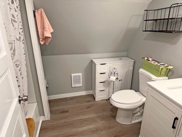 full bathroom featuring shower / bath combo, hardwood / wood-style flooring, toilet, vaulted ceiling, and vanity