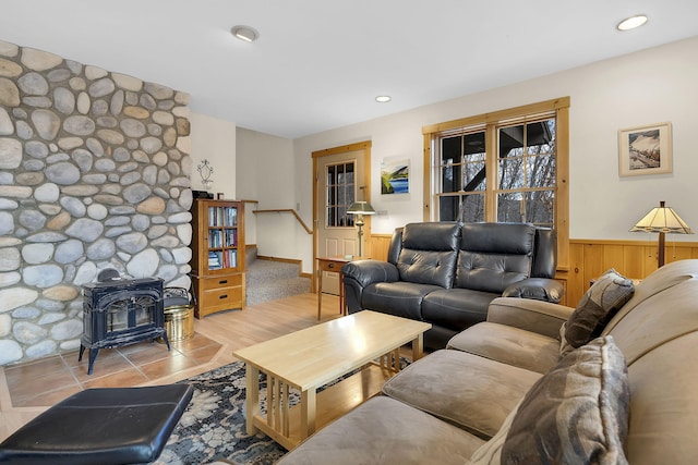 living room featuring a wood stove and wooden walls