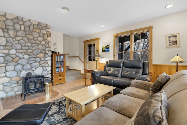 living area featuring a wainscoted wall, a wood stove, wood walls, and recessed lighting