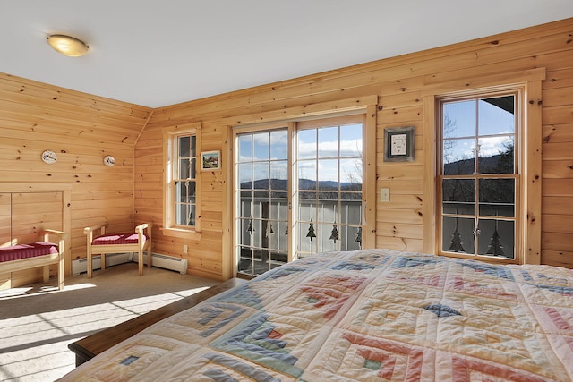 carpeted bedroom with wooden walls, access to exterior, and multiple windows