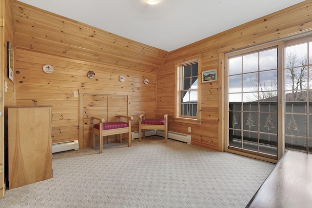 living area with a healthy amount of sunlight, lofted ceiling, wooden walls, and a baseboard heating unit