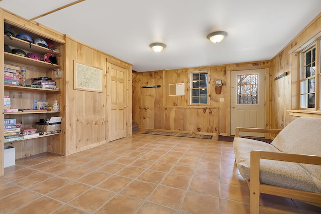 entryway featuring wooden walls and light tile patterned flooring