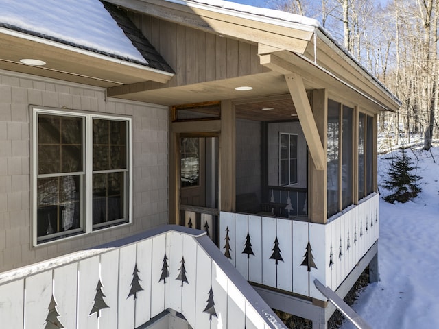 snow covered property featuring a sunroom