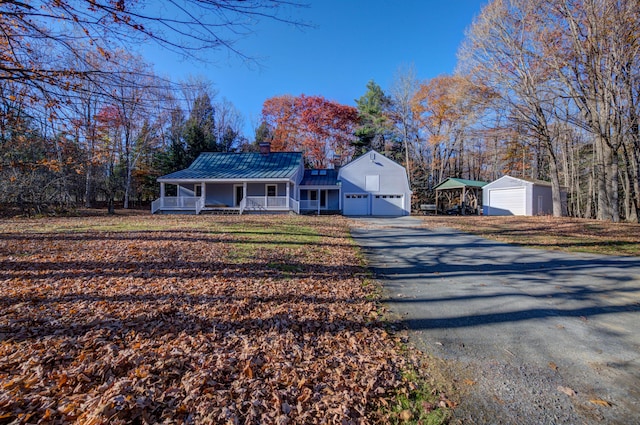 view of front of house featuring a garage, metal roof, a porch, and a standing seam roof