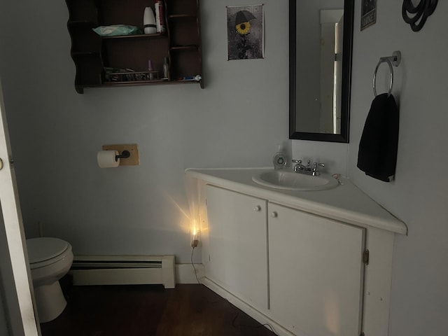 bathroom featuring vanity, toilet, and a baseboard heating unit