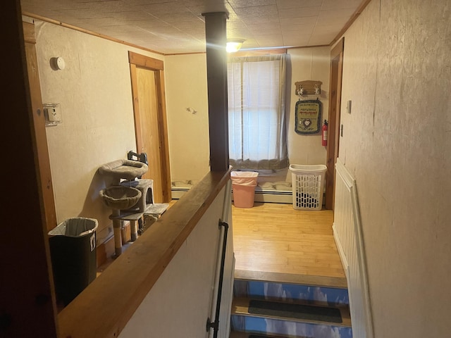 hall with light wood-type flooring and a baseboard radiator