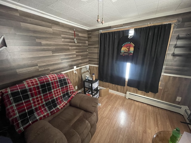 living room with hardwood / wood-style flooring, wooden walls, and a baseboard radiator