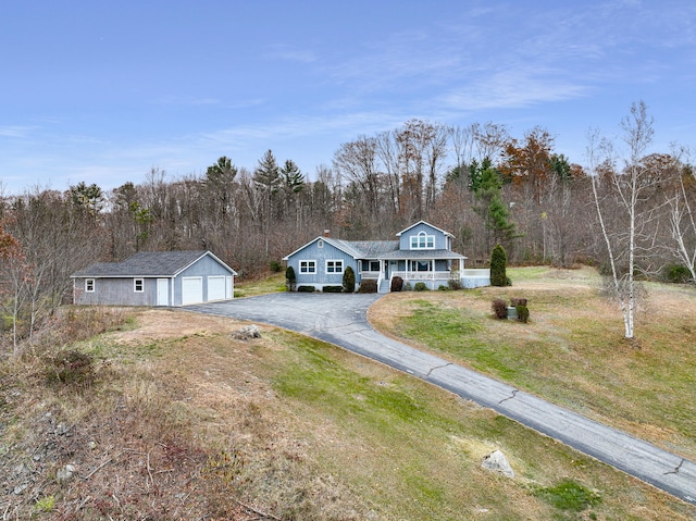 view of front of house with a porch, a garage, an outbuilding, and a front yard