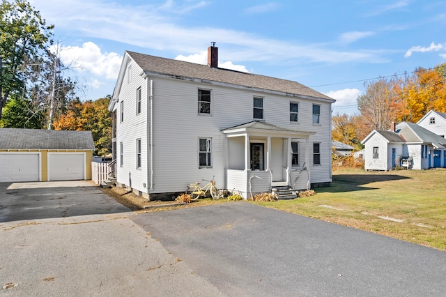 view of front of house with a front lawn, an outbuilding, and a garage