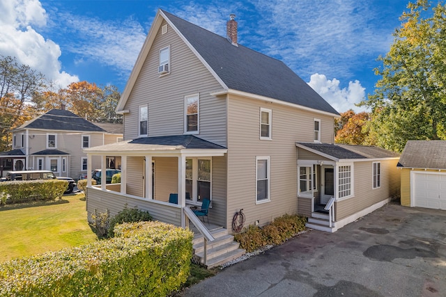 view of front of house with a front yard, a porch, and a garage