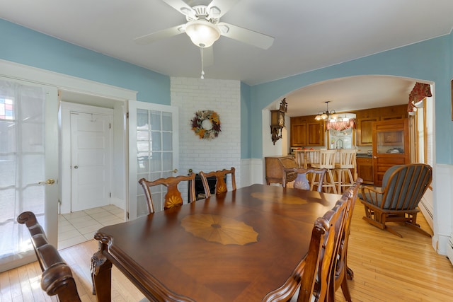 dining space featuring a wealth of natural light, ceiling fan with notable chandelier, and light wood-type flooring